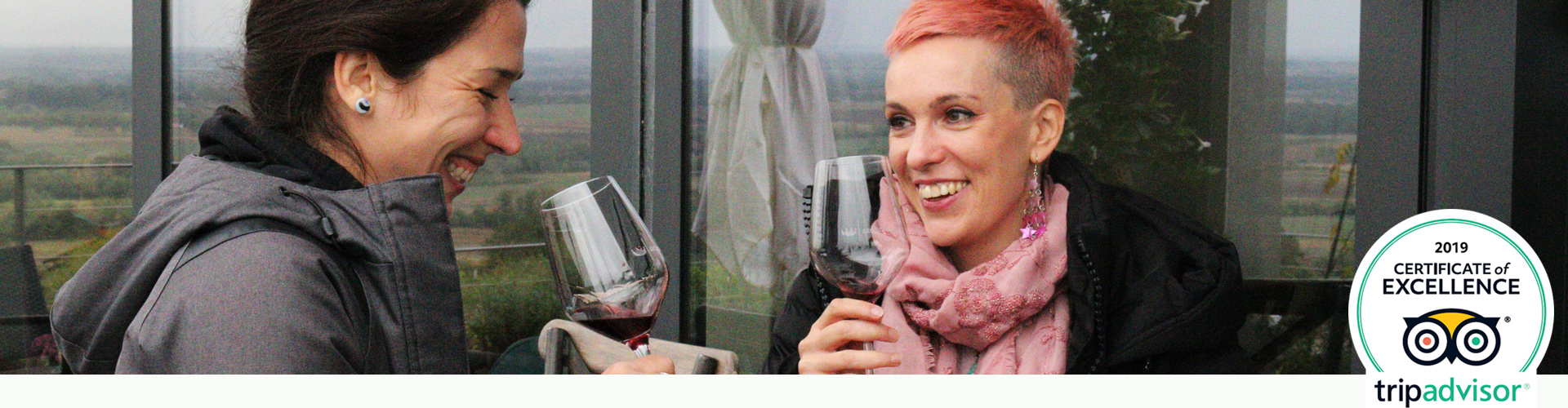 Two girls enjoy tasting wine on wine tour.