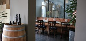 Interior of a Serbian winery tasting room with view of stainless steel tanks