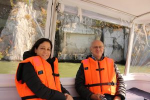 Man and woman are on the boat in front of the tabula traiana on Iron Gate gorge tour.