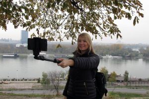 Girl tourist on Belgrade city tour is taking selfie on Kalemegdan fortress, behind her is confluence of Sava and Danube.