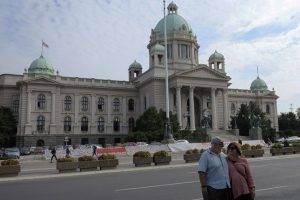Couple on Belgrade private city tour are posing in front of house of the national Assembly of Serbia