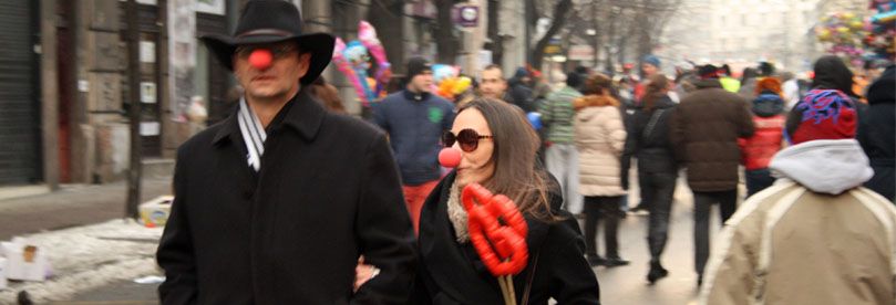 Momak i devojka sa crvenim nosevima šetaju ulicom otvorenog srca u Beogradu.