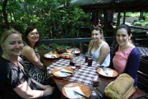 Four ladies are sitting at the tablle in restaurant and waiting lunch at the end of shared tour to Topola and Oplenac.