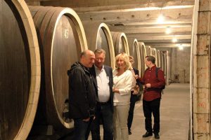 Group of tourists are talking in cellar of Royal winery on their shared small group tour to Topola and Oplenac.