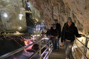 Family in Stopica cave during the Lady is posing in Sirogojno during their Serbia holiday package