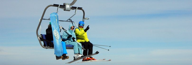 Three skiers on ski lift at Kopaonik ski resort