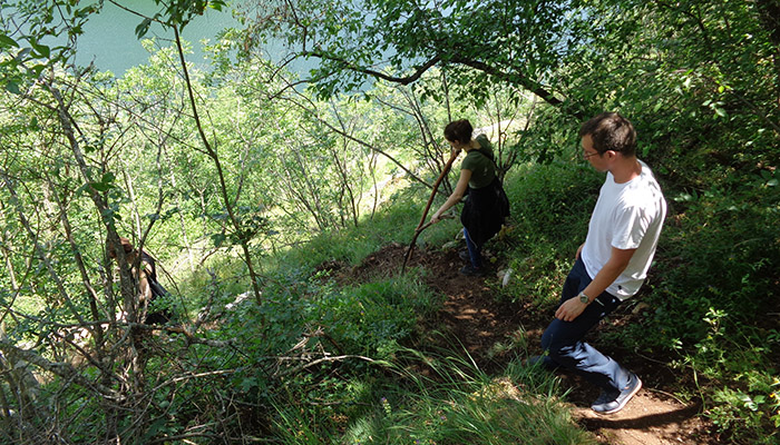 After boat ride couple of tourist are crossing slippery path to the cave..