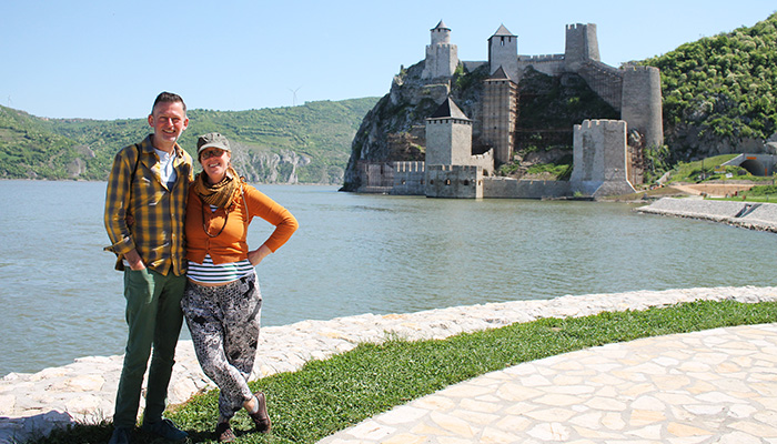 Couple is posing in front of the Golubac fortress, on of the top five destinations in Serbia.