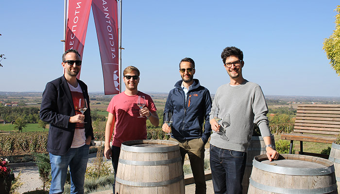 Four guys are tasting sumadian wines on the balcony.