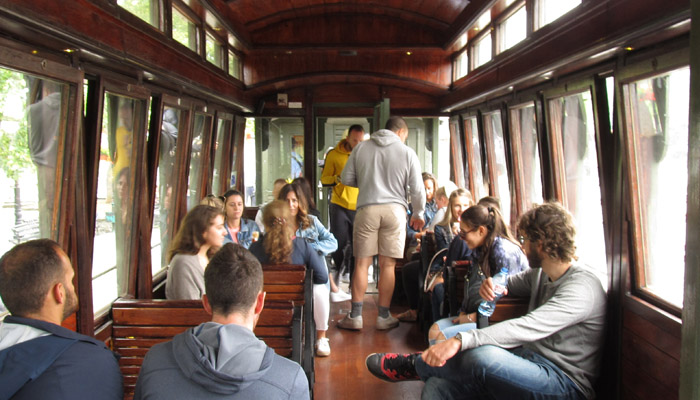 Young people are enjoying in old wagon with wooden seats and Sargan Eight train ride.