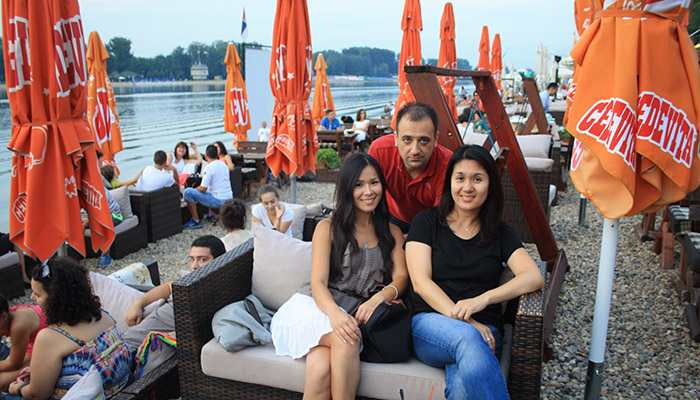 Group of friends are posing in cafe on the shore of the lake Ada Ciganlija.