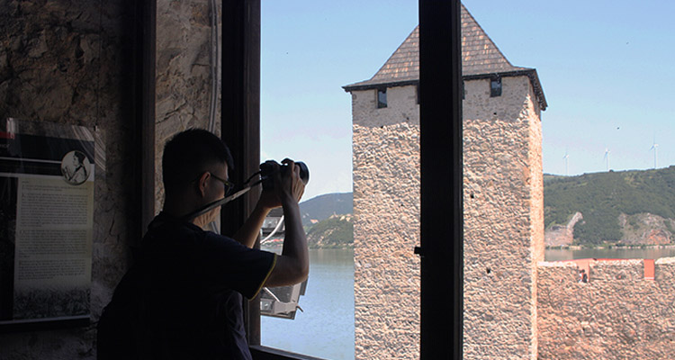 Guy is taking a photo of tower of Golubac fortress.