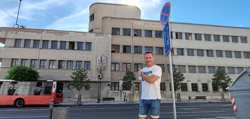 A traveler pointing at the damaged Airofrce Command building in Zemun