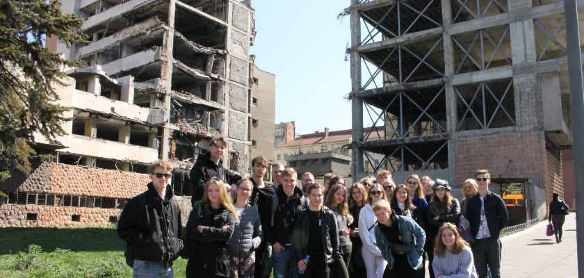Group of students from Denmark on a study tour in front of the Ministry of Defense damaged buildings