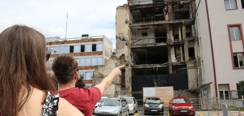 Travelers pointing at the damaged RTS building.